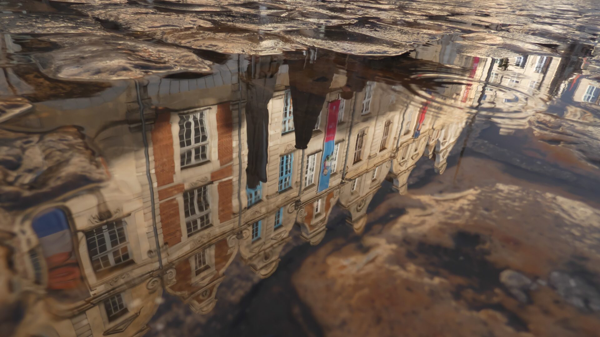 Reflet des façades dans l'eau sur la Place des Héros d'Arras